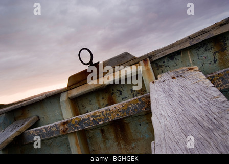 Ein altes Fischerboot liegt unter einem bewölkten Himmel. Stockfoto