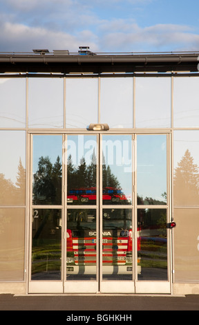 Feuerwehr LKW hinter verschlossenen Glas Garagentore, Finnland Stockfoto