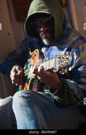 Straßenmusiker spielen Gitarre auf einem Bürgersteig im French Quarter von New Orleans, Louisiana Stockfoto