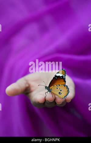 Danaus chrysippus. Plain Tiger Schmetterling auf indische Mädchen Hand. Indien Stockfoto