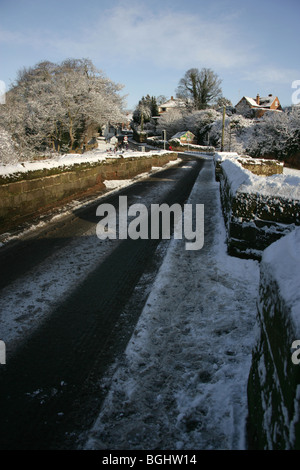 Dorf von Farndon, England. Malerisch verschneiten Winter Blick auf die mittelalterliche Holt Brücke über den Fluss Dee. Stockfoto