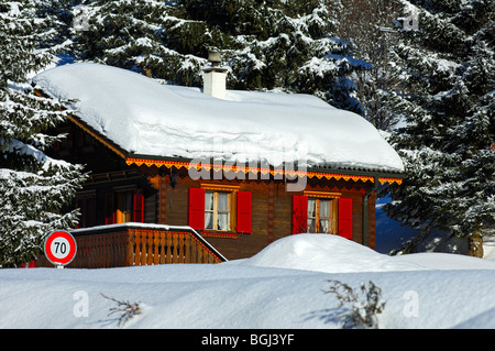 Chalet, bedeckt mit einer dicken Schicht Schnee in einem winterlichen Wald, Givrine, St. Cergue, Jura, Schweiz Stockfoto