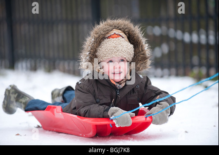 Junge auf einem Schlitten im Schnee in South East London gezogen / North Kent, England, Januar 2010 Stockfoto