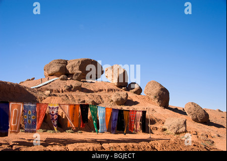 Handgefertigte Schals trocknen in der Sonne durch die seltsamen Felsformationen in der Nähe von El Kelaa Ausflüge Marokko. Stockfoto