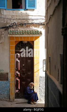 eine alte Frau sitzt in einem Hauseingang betteln in Essaouira Marokko Stockfoto