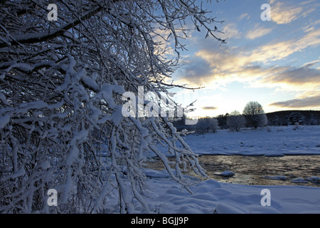 Sonnenuntergang über dem Fluss Dee in der Nähe von Banchory, Aberdeenshire, Schottland, UK, gesehen bedeckt im Winter mit Schnee. Stockfoto