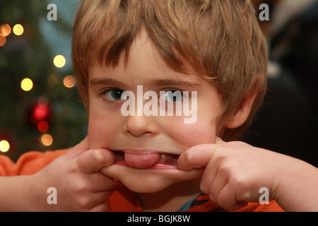 Ein Junge seine Zunge und zieht ein Gesicht Stockfoto