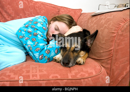 Ein Mädchen, das ist nicht gut, schläft auf ihrem Hund und einem sofa Stockfoto