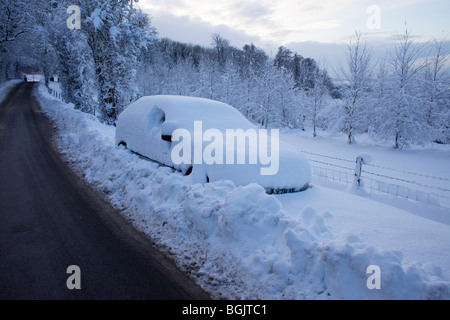 Ein Auto, gestrandet im Schnee an der Seite einer Straße in Broadway, Worcestershire, UK Stockfoto