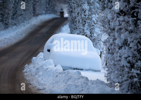 Ein Auto, gestrandet im Schnee an der Seite einer Straße in Broadway, Worcestershire, UK Stockfoto