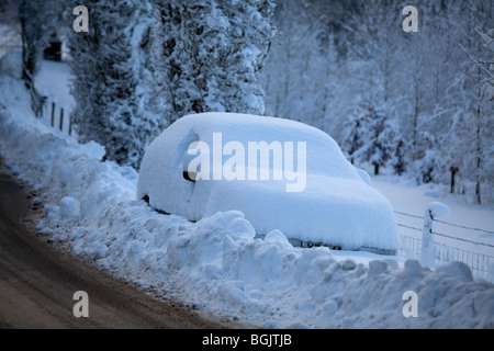 Ein Auto, gestrandet im Schnee an der Seite einer Straße in Broadway, Worcestershire, UK Stockfoto