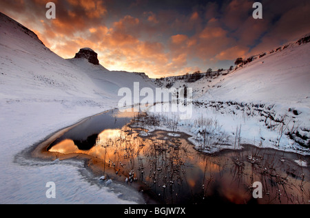 Sonnenuntergang über Peter Stein in The Peak District während der Schnee von Anfang 2010. Stockfoto