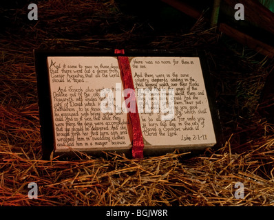 Dieses Buch des Lukas aus Schriften ist groß erzählen die Weihnachtsgeschichte im Heu in der Krippe mit dramatische Beleuchtung in der Nacht. Stockfoto