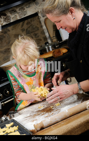 Stock Foto von einem vier Jahre alten Mädchen und ihre Mutter backen gemeinsam in der Küche. Stockfoto