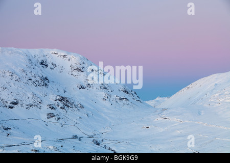 Rot Geröllhalden und Kirkstone Pass abgedeckt im Schnee bei Sonnenuntergang von Wansfell im Lake District, UK. Stockfoto