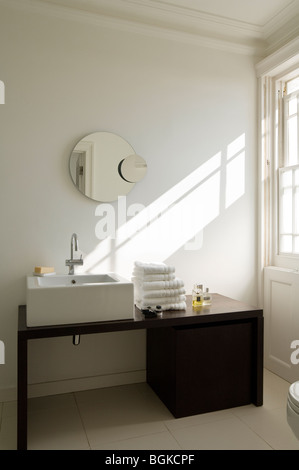 Modernes Bad mit schwarzen Waschtisch und runder Spiegel Stockfoto