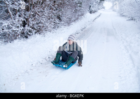 Schlittenfahren oder Rodeln im Schnee, Hampshire, England. Stockfoto