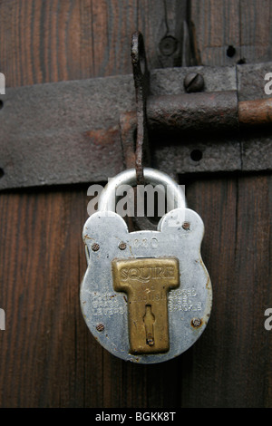 Squire Vorhängeschloss auf einer alten Holztür Stockfoto