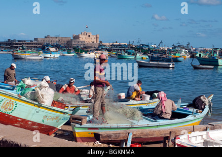 Fischer reparieren Netze auf ihre Angelboote/Fischerboote in den Hafen von Alexandria, Ägypten. Stockfoto