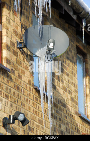 Eine Satellitenschüssel mit Eiszapfen. GROßBRITANNIEN, 2010. Stockfoto