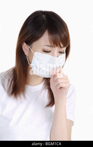 Junge Frau bekam eine Erkältung, Husten und einen Mundschutz tragen Stockfoto