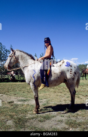 Blackfeet Teenager gekleidet in Mitte 1800 Ornat mit Kavallerie Hut sitzt auf ein Appaloosa Pferd in Browning Montana bareback Stockfoto