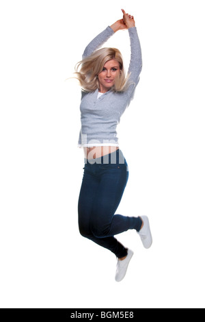 A pretty young blond woman jumping in the air, isolated on a white background. Slight motion blur. Stockfoto