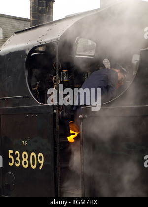 Feuerwehrmann mit Dampflok Anheizen des Kessels. North York Moors Railway. Stockfoto