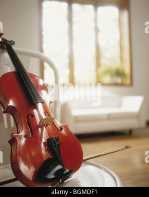 Violine auf Stuhl im hellen Wohnzimmer Stockfoto