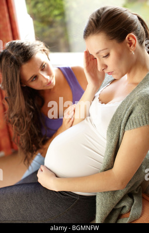 Tröstliche schwangere Freundin Stockfoto