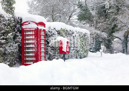 Ein rotes britische Telefon und Briefkasten im Schnee. Stockfoto