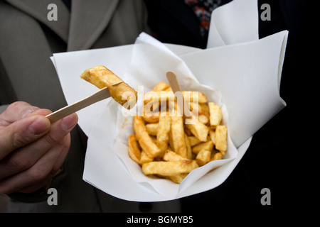 Ein junges Paar genießen Sie einen kleinen Teil der Chips vor Bankern traditionellen Fish &amp; Chips Restaurant und Take-away, Brighton, UK. Stockfoto