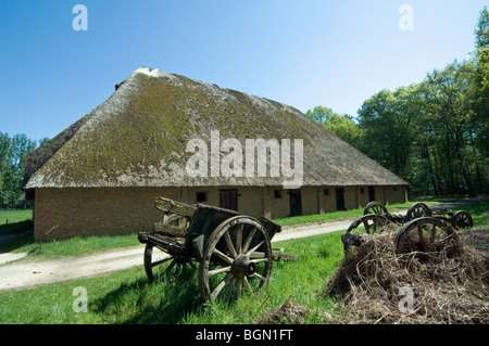 Alten Holzkarren vor traditionellen Scheune mit Reetdach in das Freilichtmuseum Bokrijk, Belgien Stockfoto