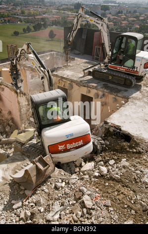 Mini Mechanische Bagger auf der fünfzehnten Stockwerk eines Gebäudes in der Dekonstruktion. Stockfoto