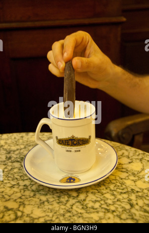 Nahaufnahme einer Person eintauchen Schokolade in heiße Schokolade im Café Tortoni in Buenos Aires, Argentinien Stockfoto