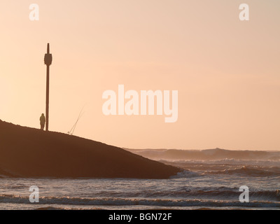 Mann Meeresangeln vom Fass Rock im frühen Abendlicht, Bude, Cornwall Stockfoto