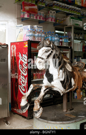 herrliche antike mechanische Holzpferd mit abgenutzten Ledersattel am Eingang der Bodega im zentralen Bezirk der Stadt Oaxaca gemalt Stockfoto