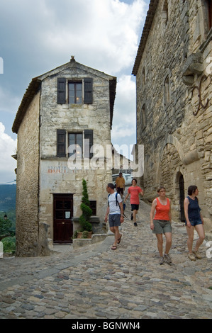 Touristen zu Fuß durch mittelalterliche Gasse im Dorf Lacoste, Vaucluse, Provence-Alpes-Côte d ' Azur, Provence, Frankreich Stockfoto