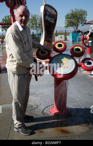 Älterer Mann genießen Universal Studios in Hollywood, Los Angeles, Vereinigte Staaten an der Cola-Soak-Maschine Stockfoto