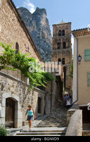 Touristen in Gasse und die Kirche Notre-Dame-de-Assomption, Provence, Alpes-de-Haute-Provence, Frankreich Stockfoto