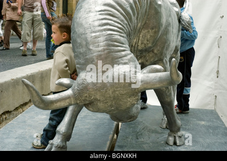 Arles. Frankreich - Feria Stierkampf Festival. Straßenszene. Französische Kinder posieren für Fotos mit Stier Skulptur außerhalb Stockfoto