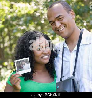 Porträt einer jungen Frau zeigt ein Foto und ein Mitte erwachsenen Mann stand neben ihr Stockfoto