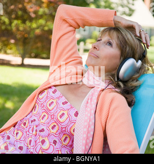 Reife Frau mit Kopfhörern Musik hören Stockfoto