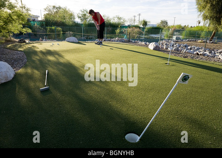 Frau üben Golf auf dem Putting green Stockfoto