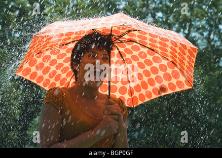 Reife Frau, die unter einem Dach bei Regen und schreien Stockfoto