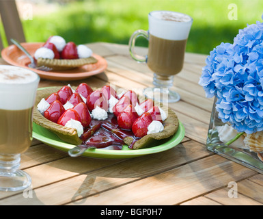 Nahaufnahme von einem Erdbeer Torte und zwei Gläser Schoko Milchshake auf einem Tisch Stockfoto