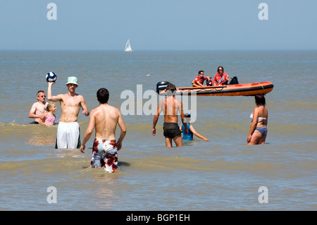 Strand Rettungsschwimmer in Rettungsboot gerade Touristen spielen im Wasser der Nordsee, Blankenberge, Belgien Stockfoto