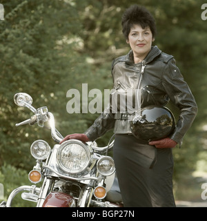 Porträt einer reifen Frau stand neben einem Motorrad und halten einen Sturzhelm Stockfoto