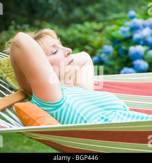 Seitenansicht einer reifen Frau liegen in der Hängematte Stockfoto