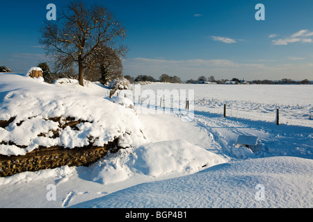 Schneebedeckte Roman Wall mit Blick auf St. Mary die Jungfrau Kirche, geht, Hampshire, Uk Stockfoto